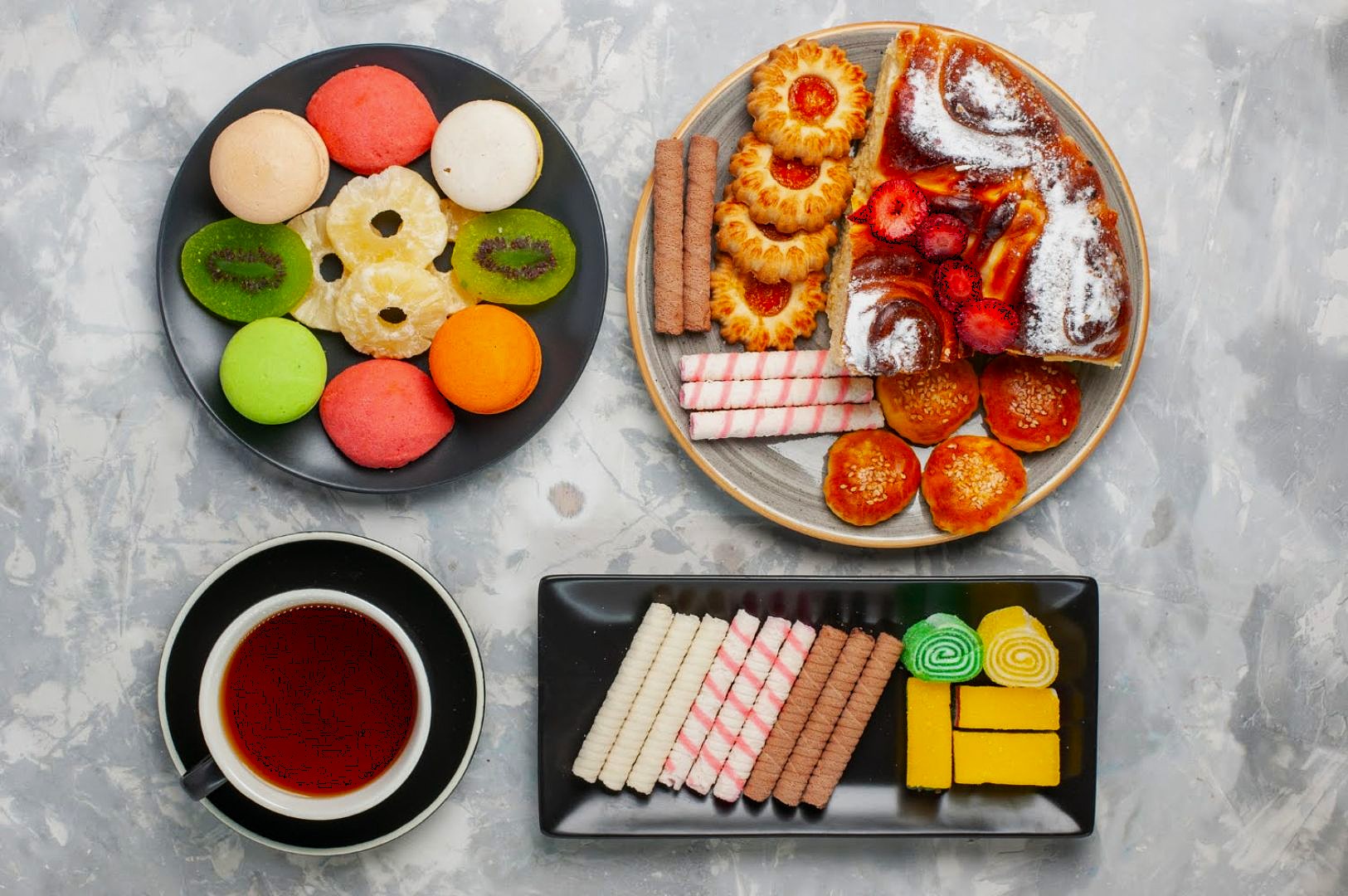 An assortment of colorful pastries and biscuits on three plates, with a cup of tea. The scene is inviting and vibrant, showcasing a variety of textures.