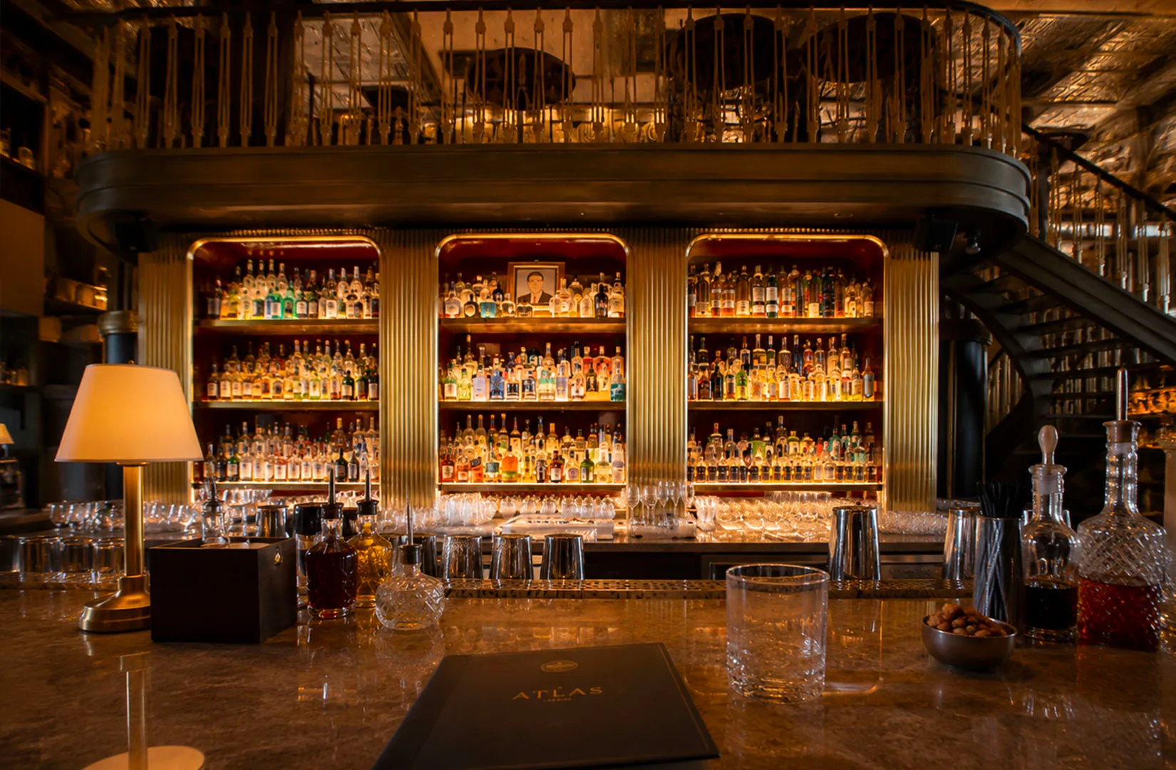 Upscale bar interior with marble counter and spirit shelves.