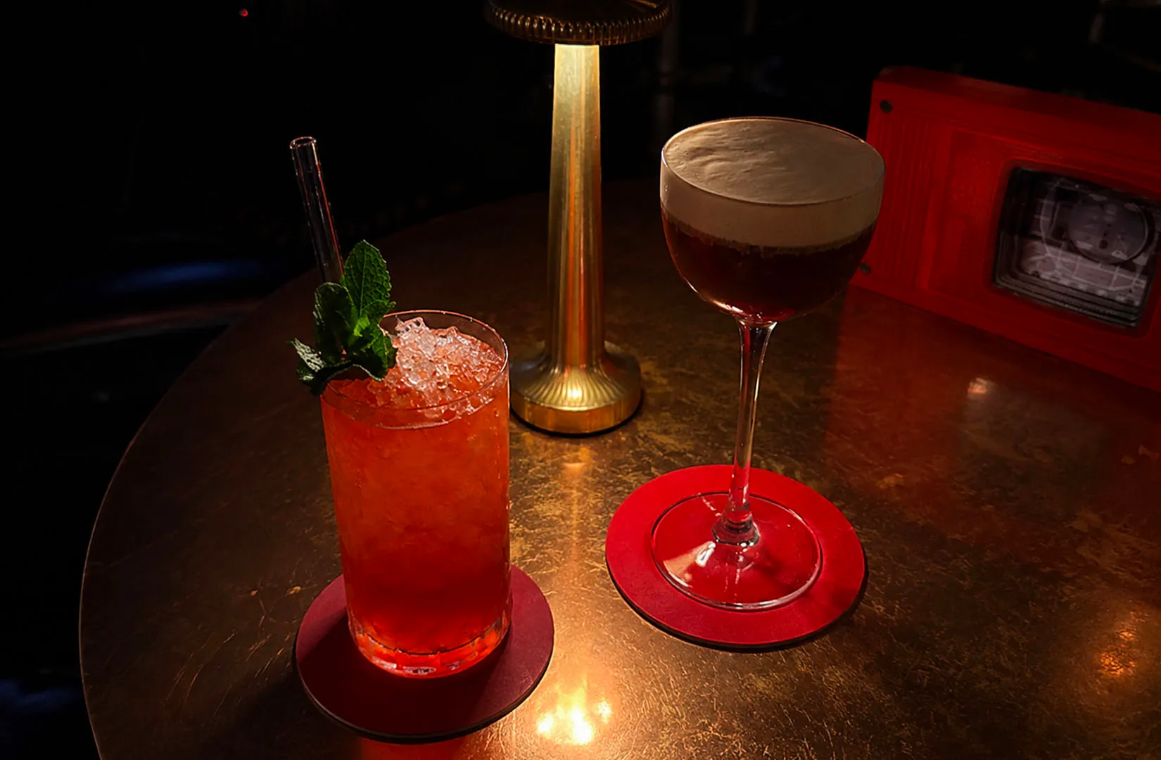 Wine and cocktail glasses on a marble table inside a lounge bar.
