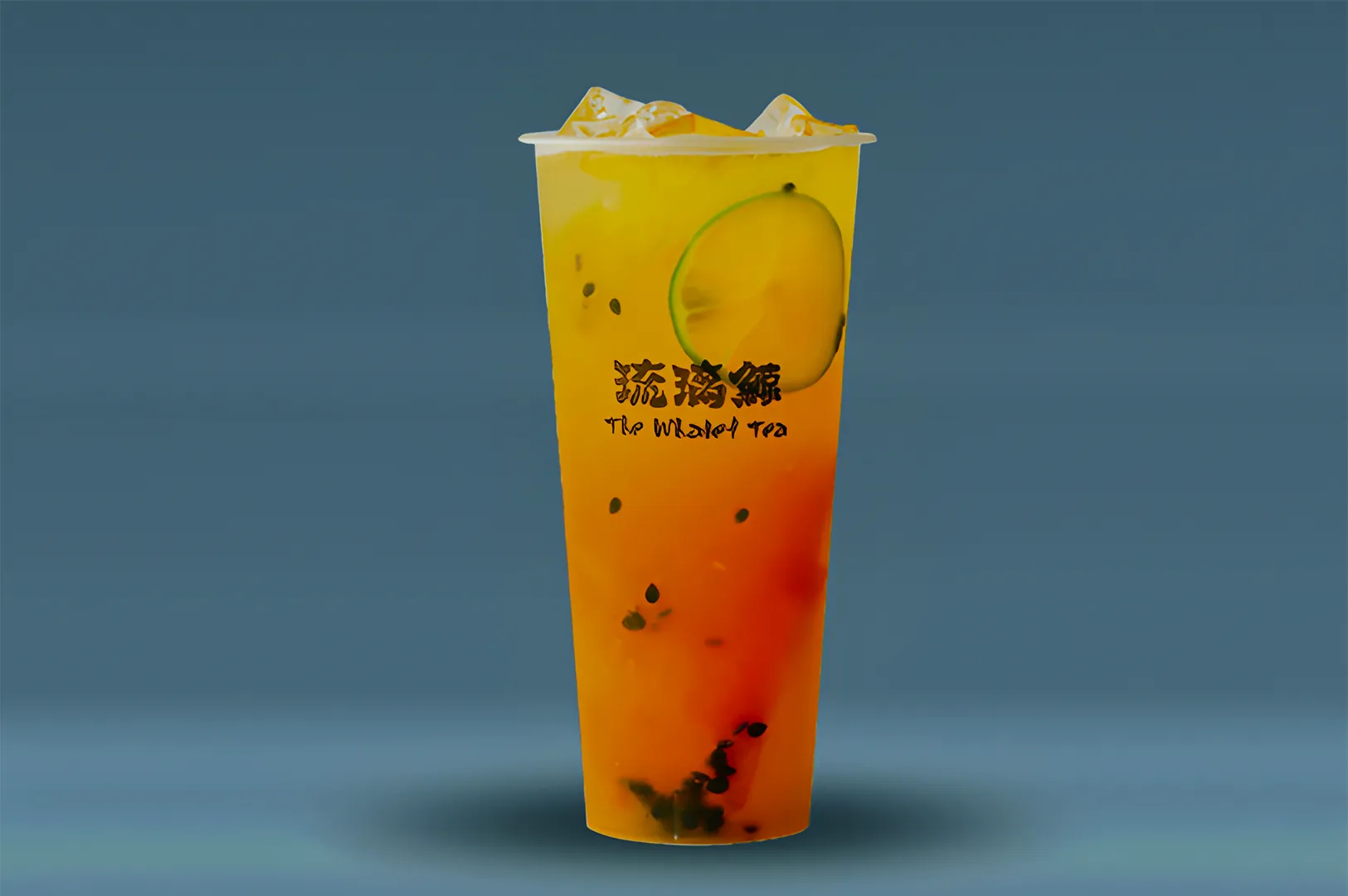 Tall plastic cup of iced tea with lime slice and dark seeds against a blue background. The label reads "The Whale Tea" in bold, stylish font.