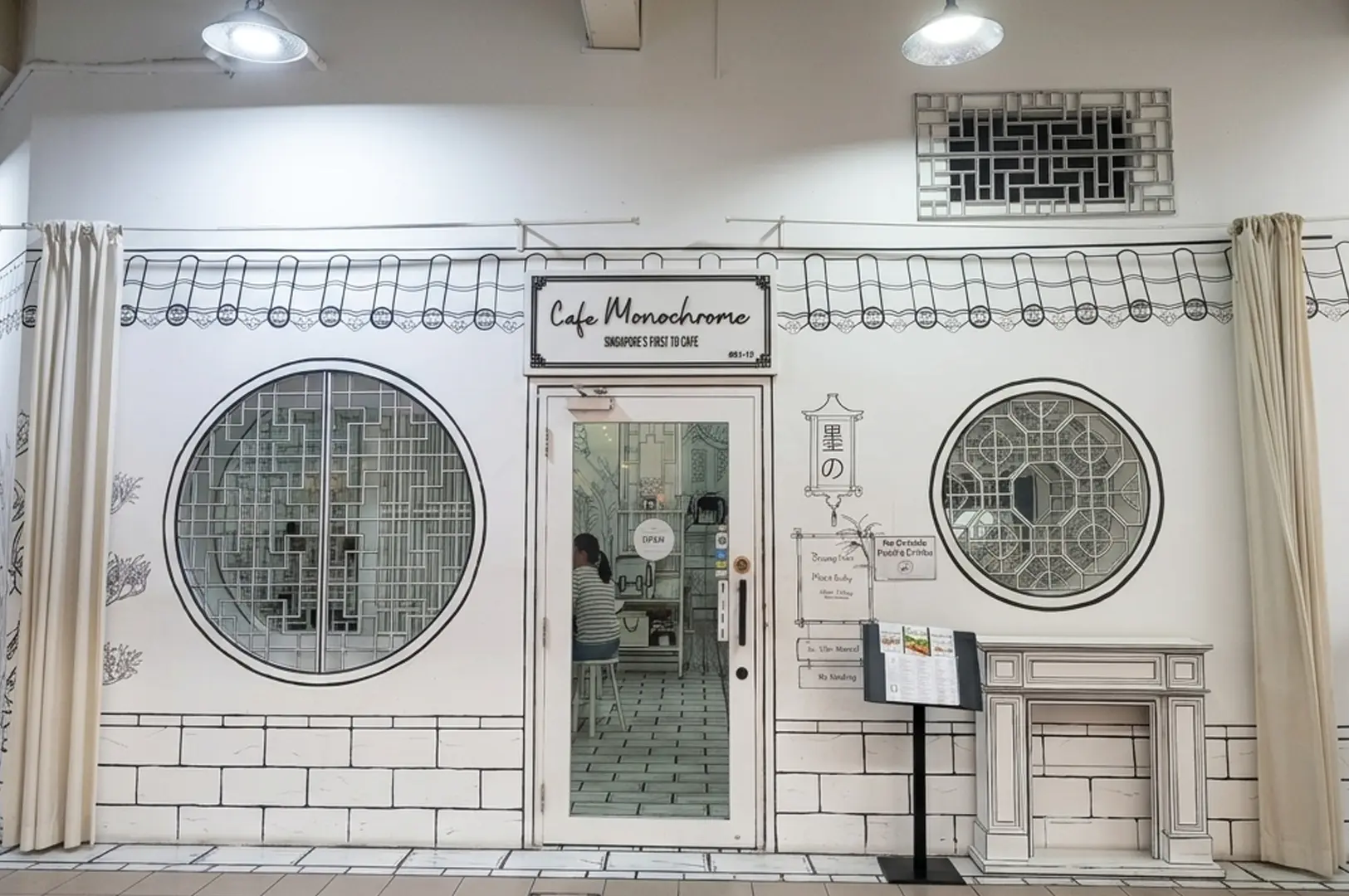 Café Monochrome with 2D line-drawn facade, round Chinese lattice windows, and Singapore's First 2D Cafe sign
