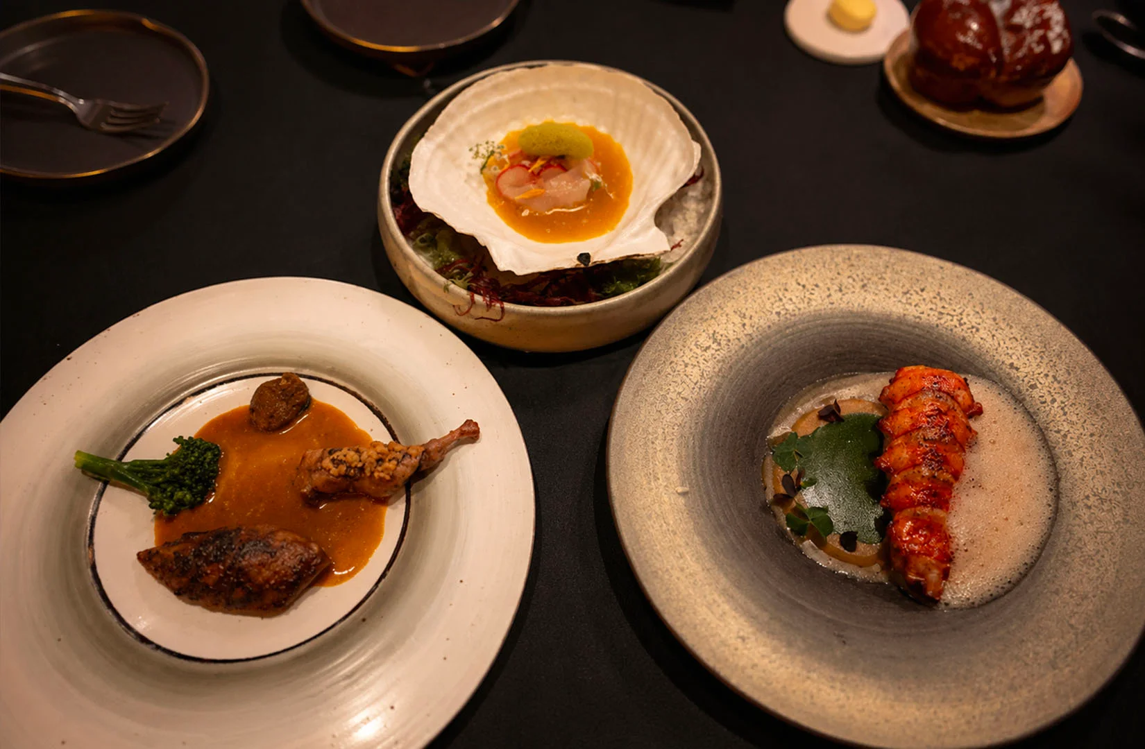 Modern fine dining dishes served on dark table setting
