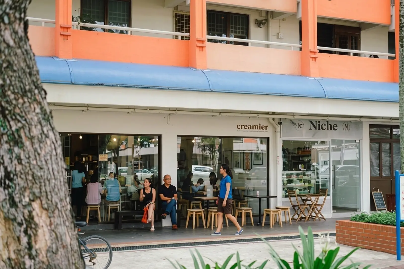 Creamier ice cream shop exterior in Toa Payoh with customers sitting at outdoor tables under colorful orange and blue building