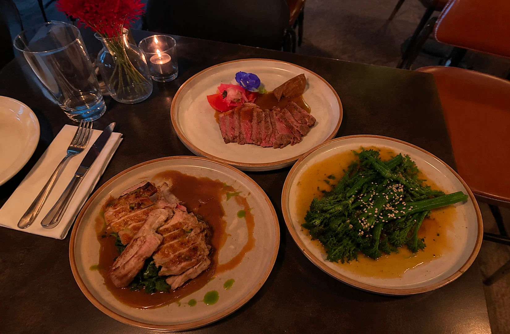 Restaurant table with steak, pork, and vegetable dishes