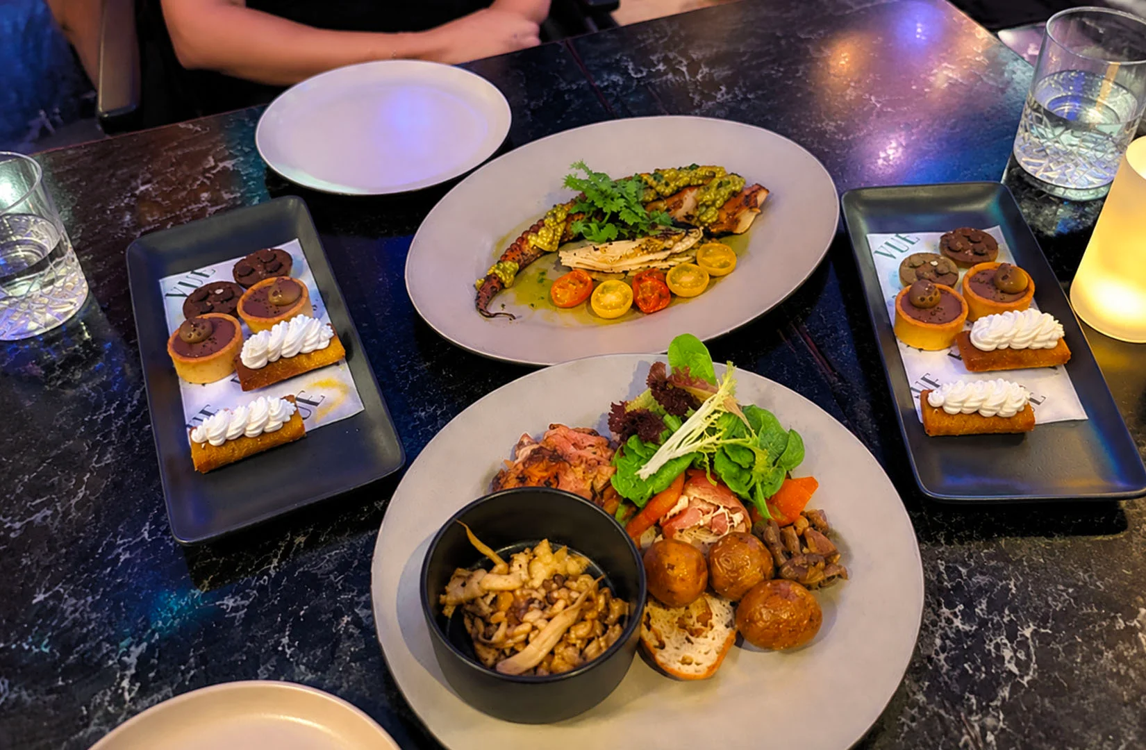 Shared dining table with appetizers, main dishes, and desserts