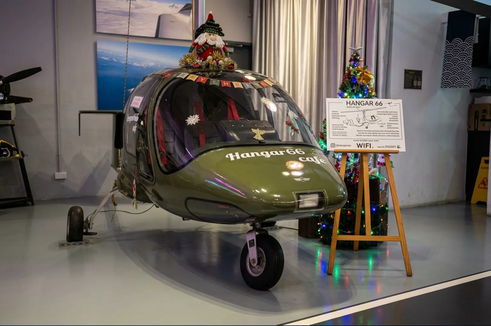 Christmas-decorated aircraft with Hangar 66 cafe logo and a festive tree