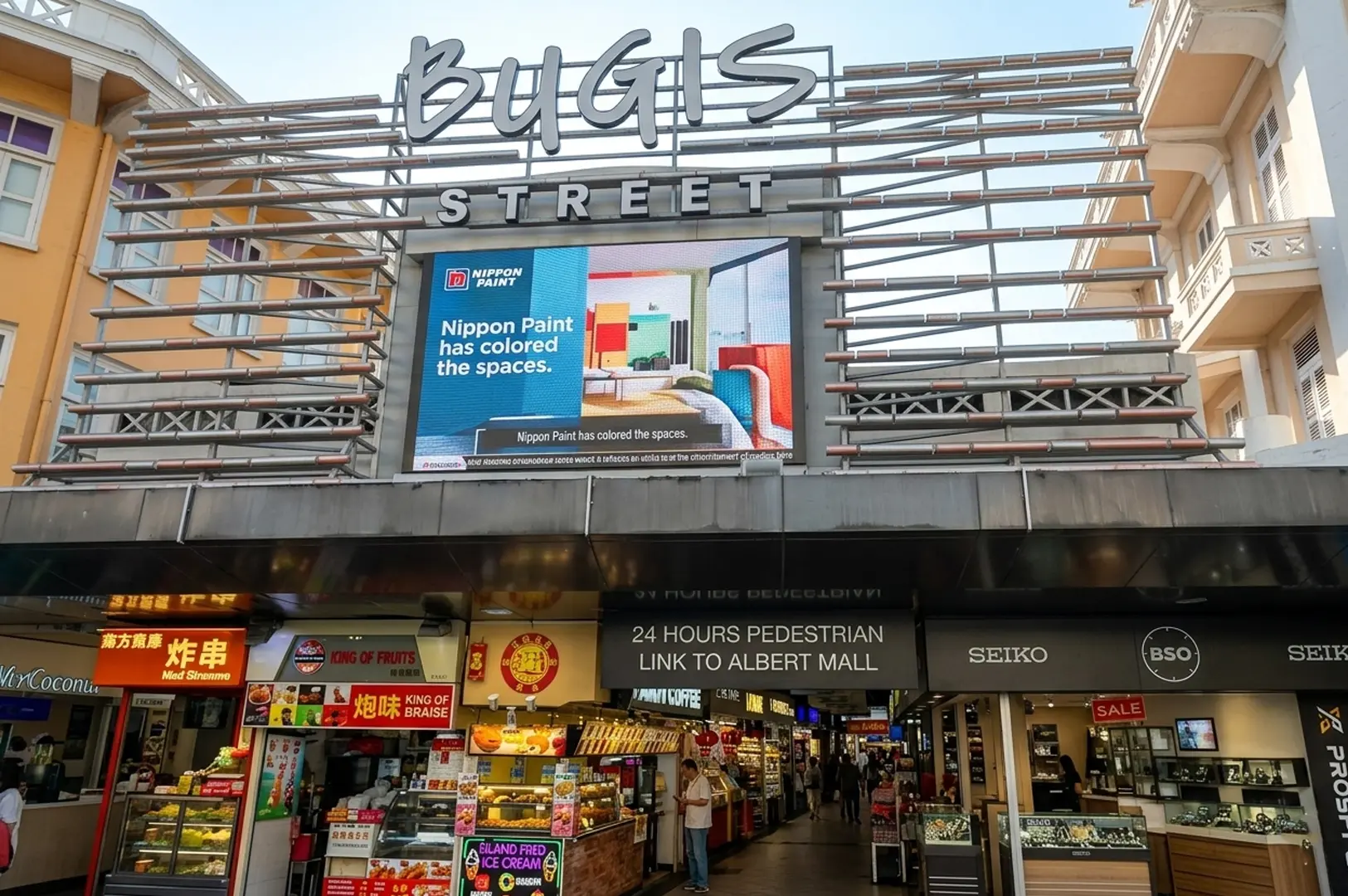 Bugis Street market entrance with food stalls and shops below large sign