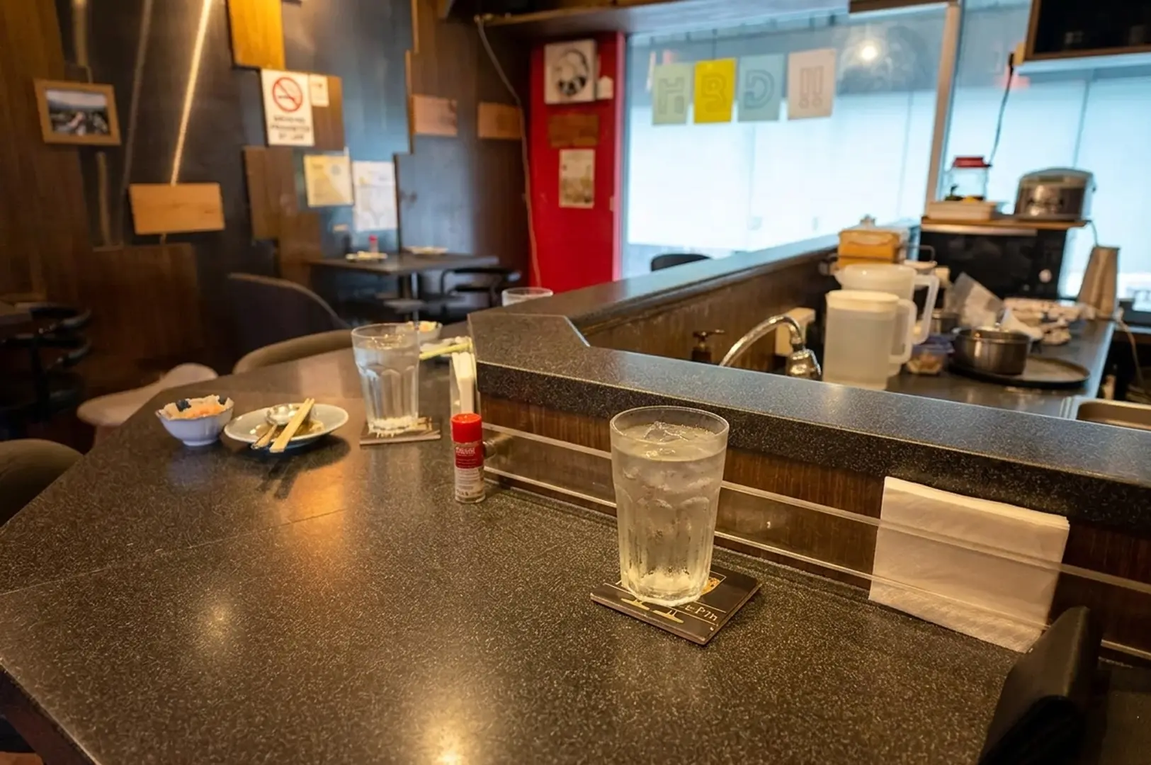 Counter seating at Bistro Du Le Pin with water glasses and condiments set for omakase dining