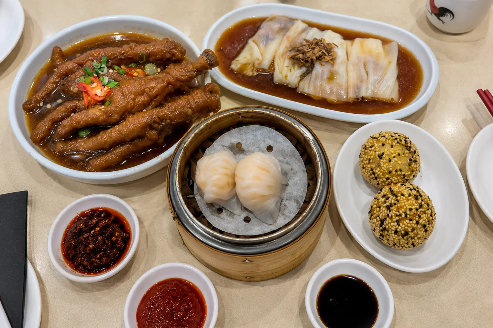 Assorted dim sum dishes including chicken feet, dumplings, and sesame balls