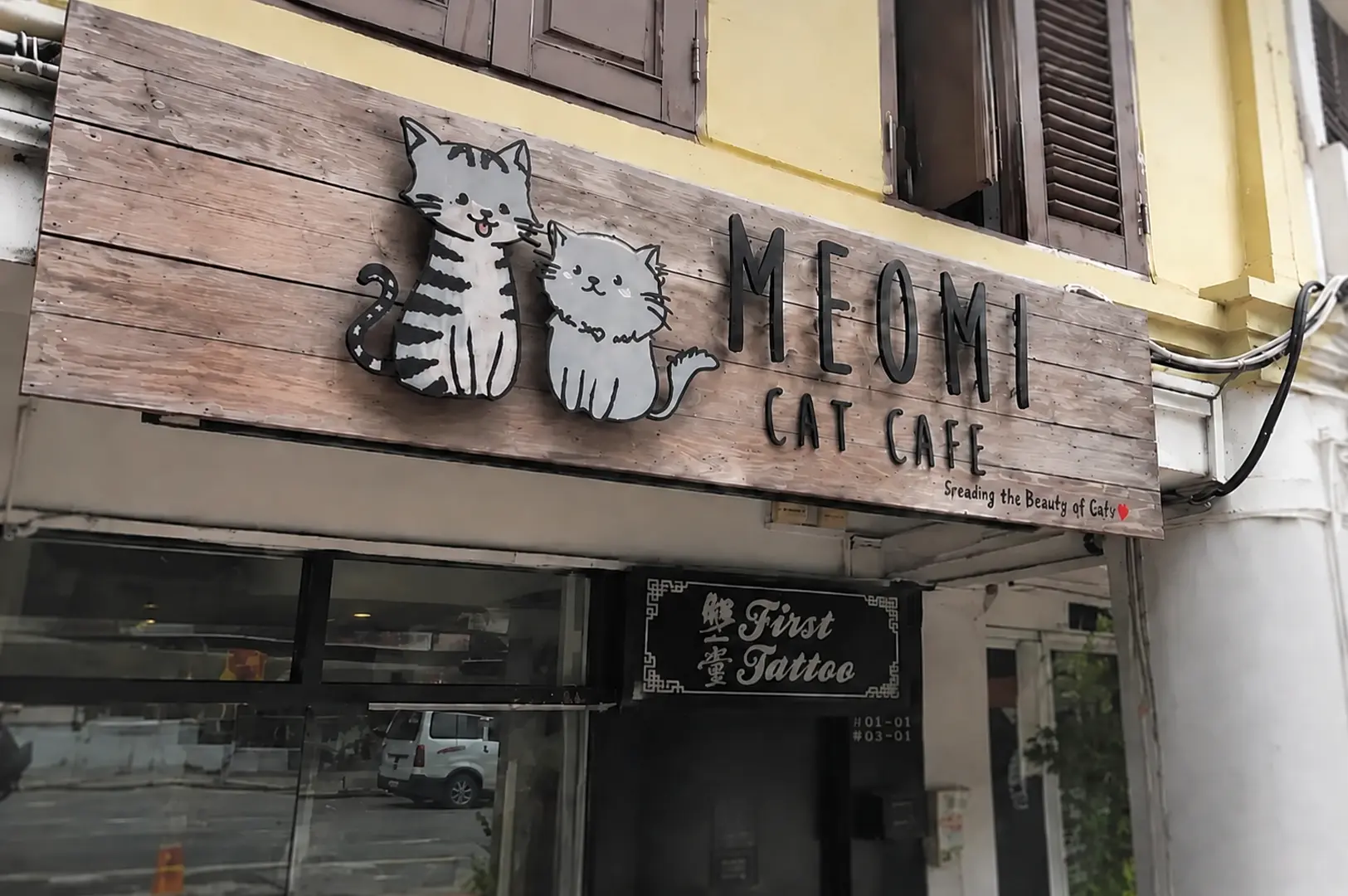 Exterior sign of Meomi Cat Cafe on North Bridge Road with playful cat logo above a restored heritage shophouse entrance in Singapore.