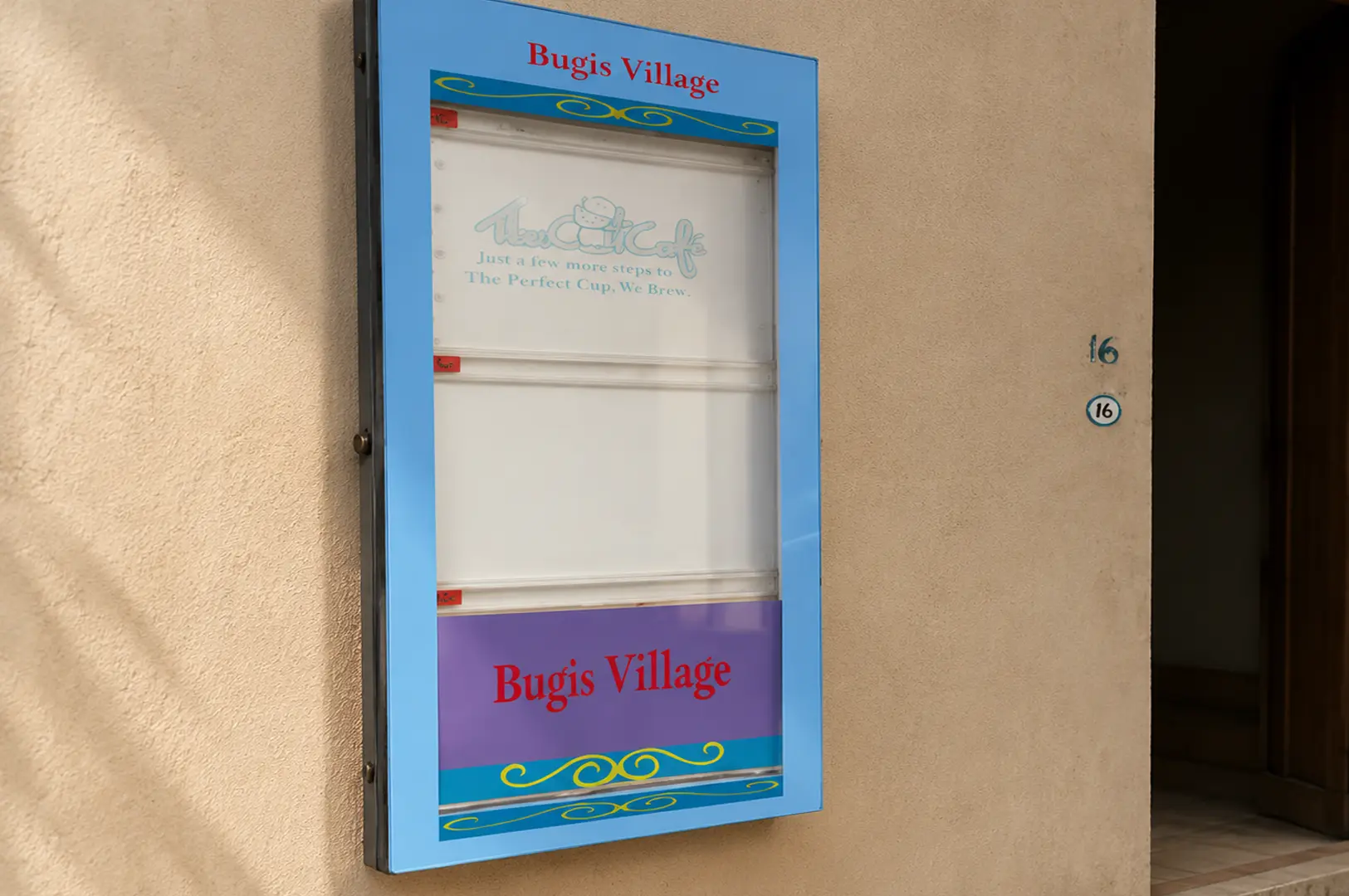 A blue Bugis Village directory sign on a beige wall displays the logo and slogan for The Cat Cafe