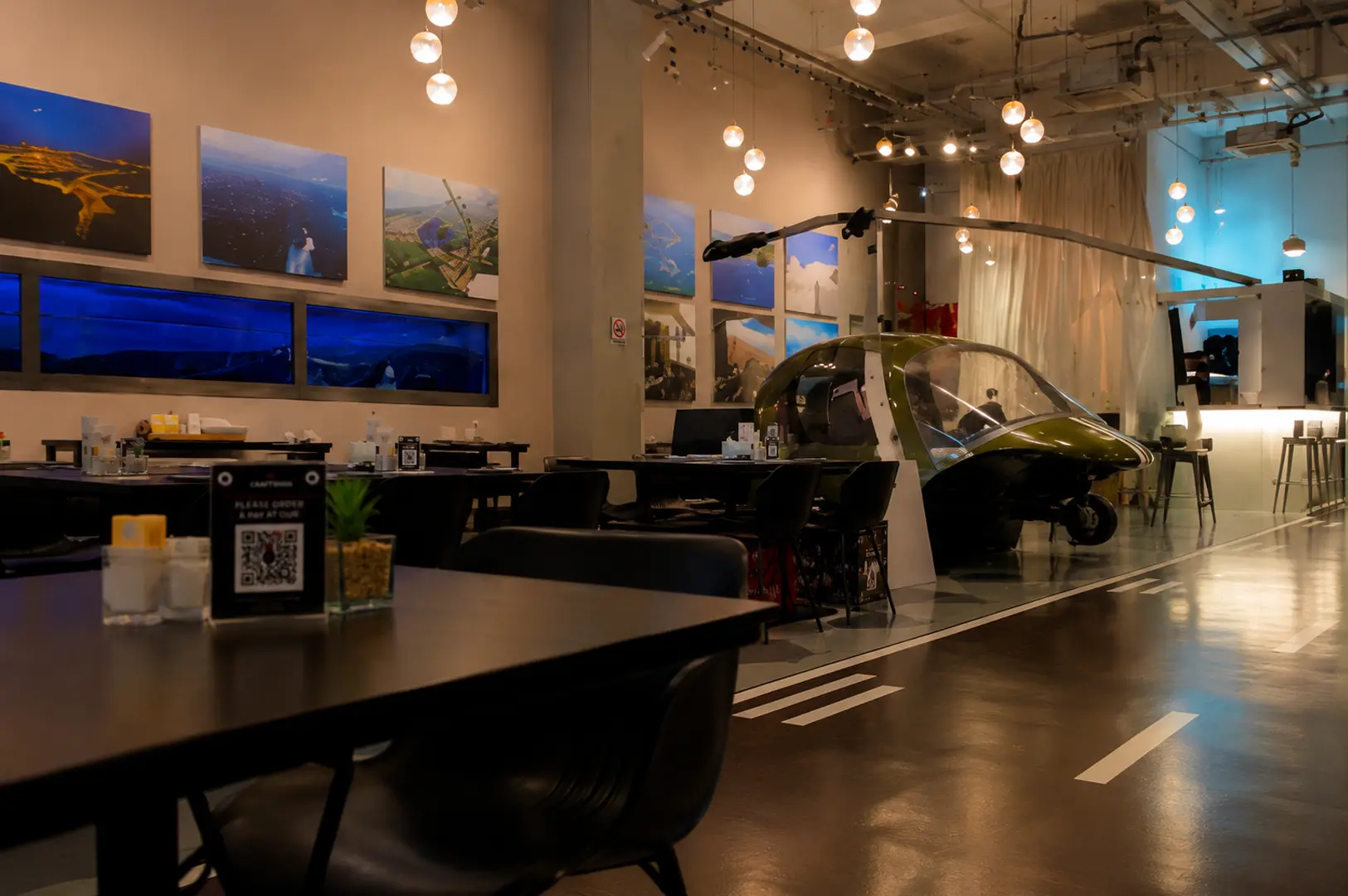 Interior of Hangar66 Cafe with a helicopter display, warm lighting, and aviation-themed decor.