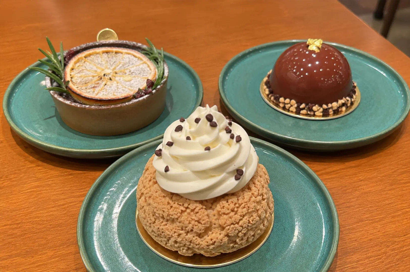 Three handcrafted signature desserts beautifully presented on green ceramic plates, showcasing the artisanal creations of Mr. Bucket Chocolaterie.