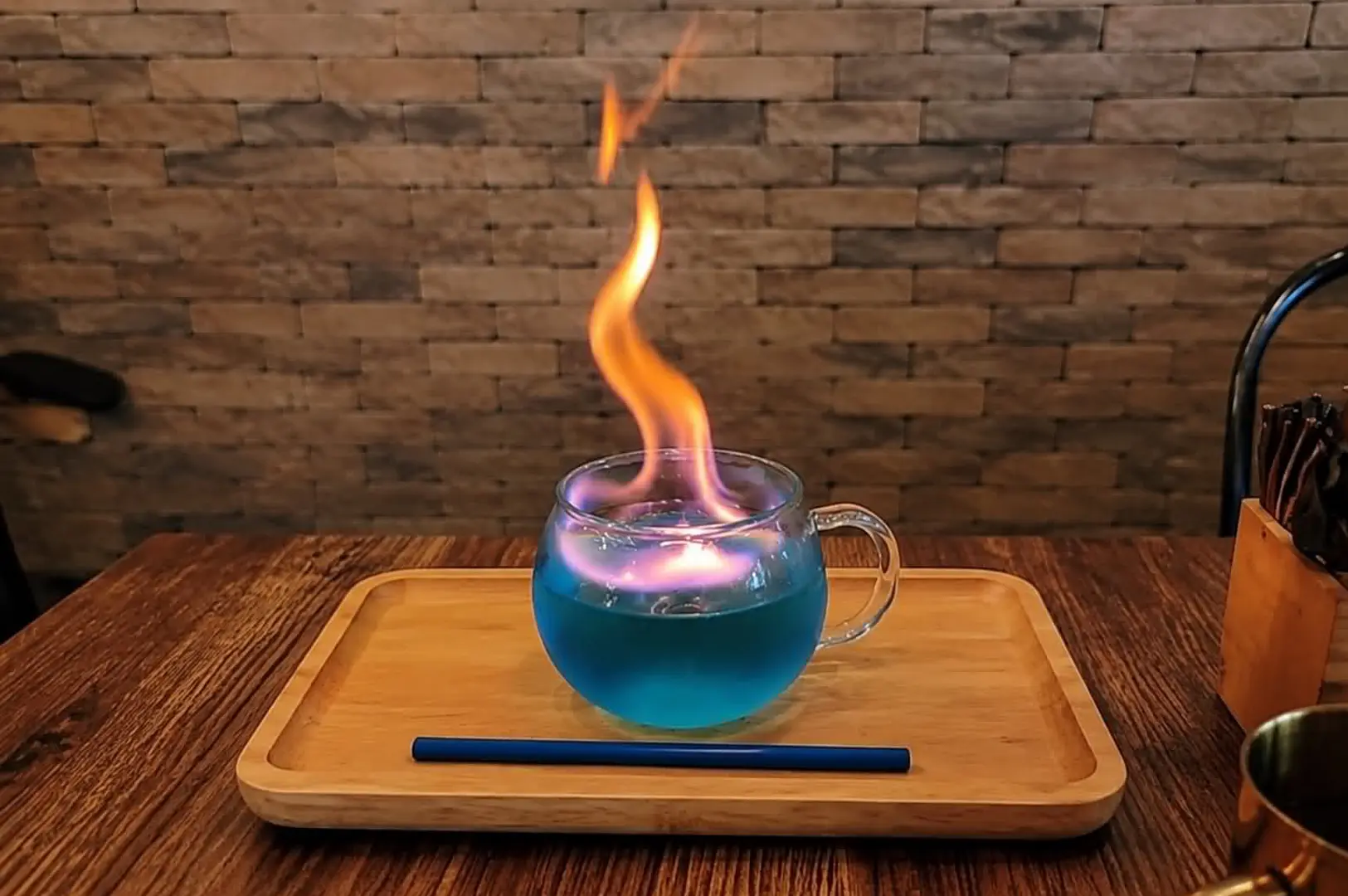 Blue flaming magical drink served on a wooden tray at Platform 1094.