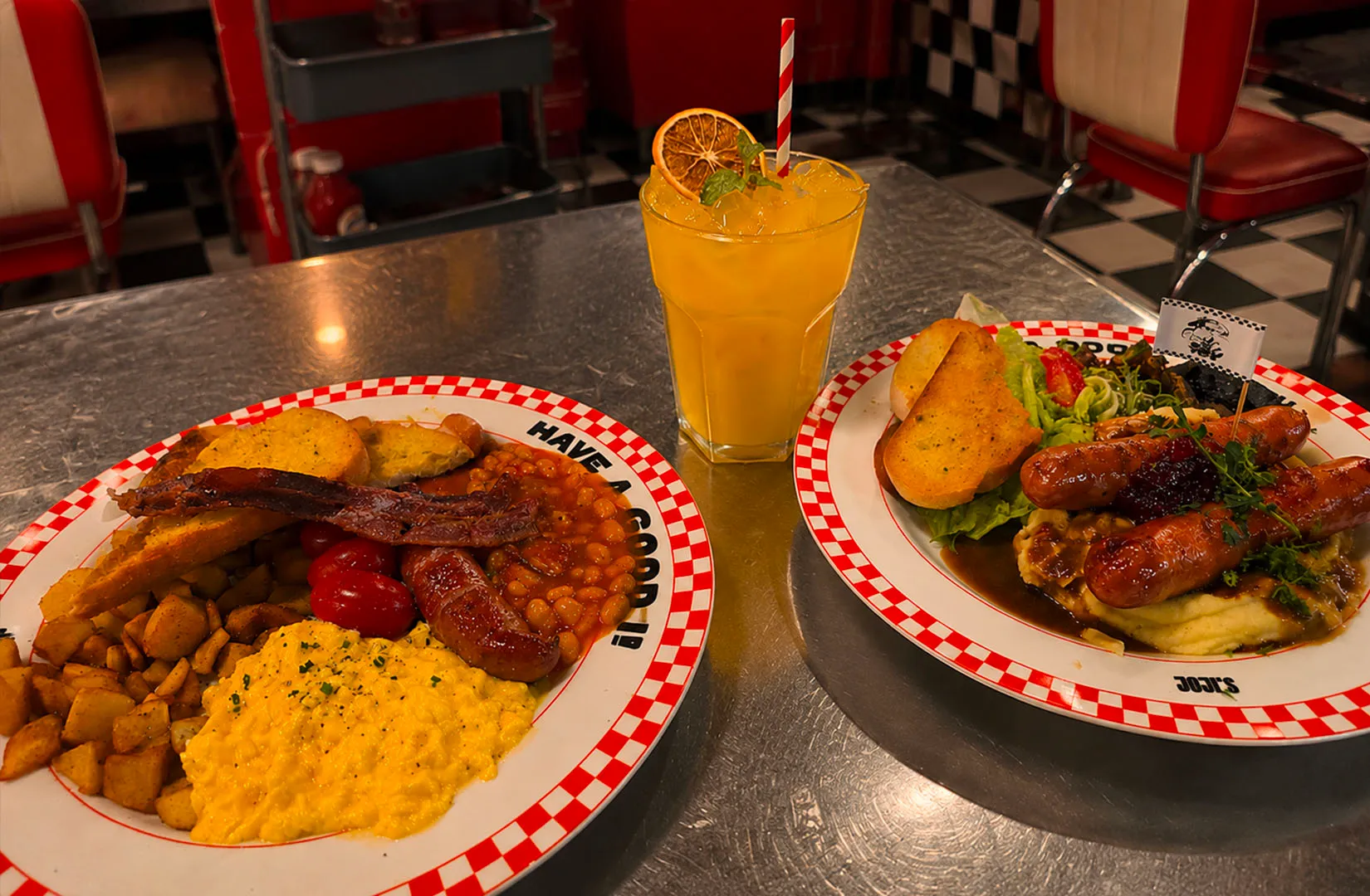 Retro diner-style breakfast plates with eggs, sausages, beans, and a drink in a neon-lit interior.