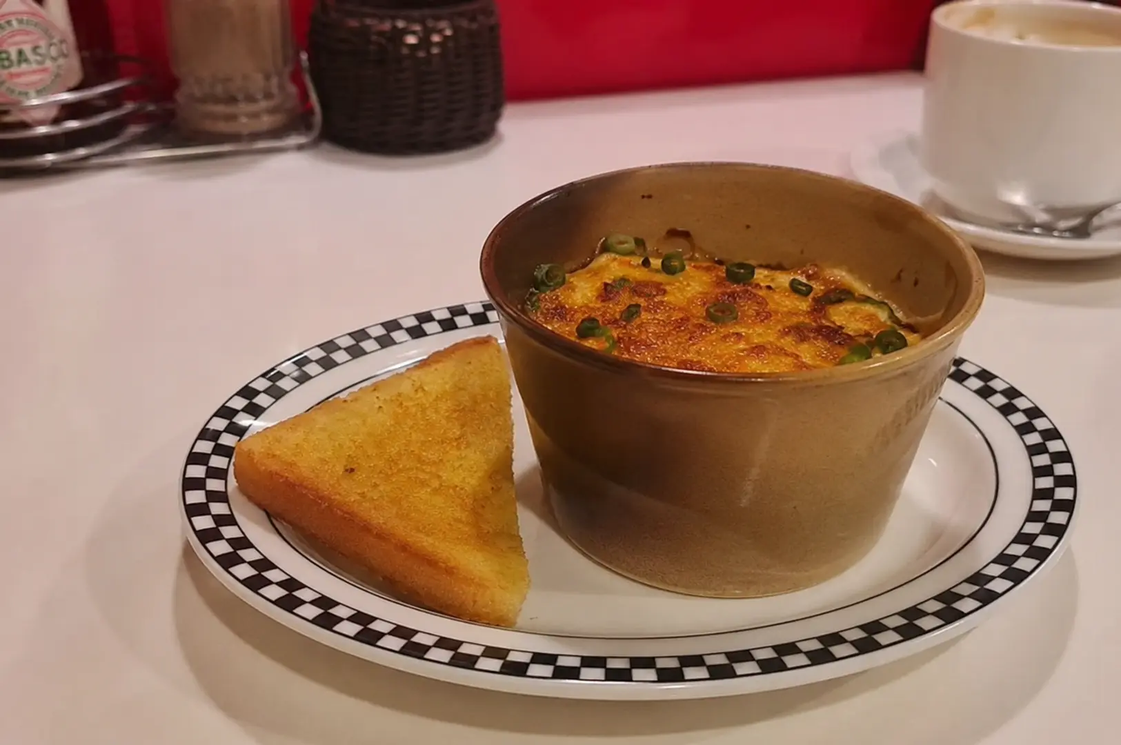 Creamy baked mac and cheese topped with spring onions and served with buttered toast at Joji’s Diner.