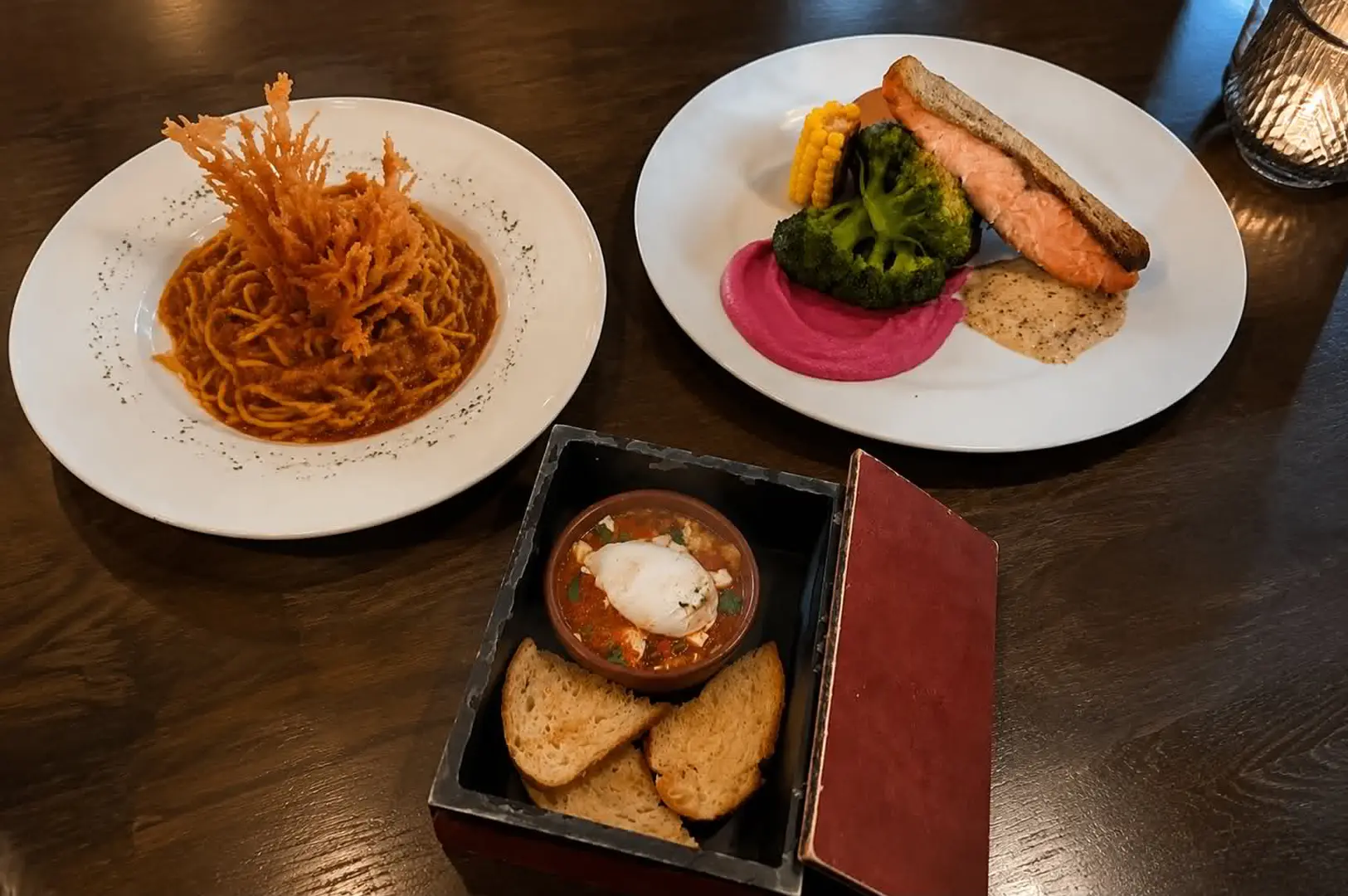 Fantasy-themed dishes including pasta, salmon, and appetizers on a dining table.