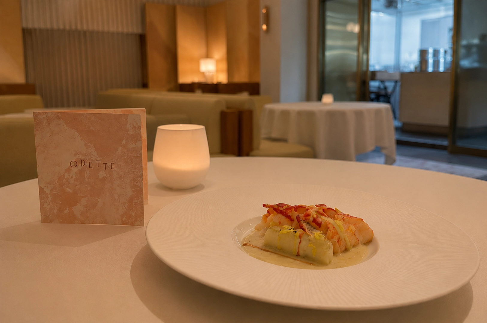 Scottish blue lobster with cheese elegantly presented on a white plate at Odette Singapore with a refined fine dining setting.