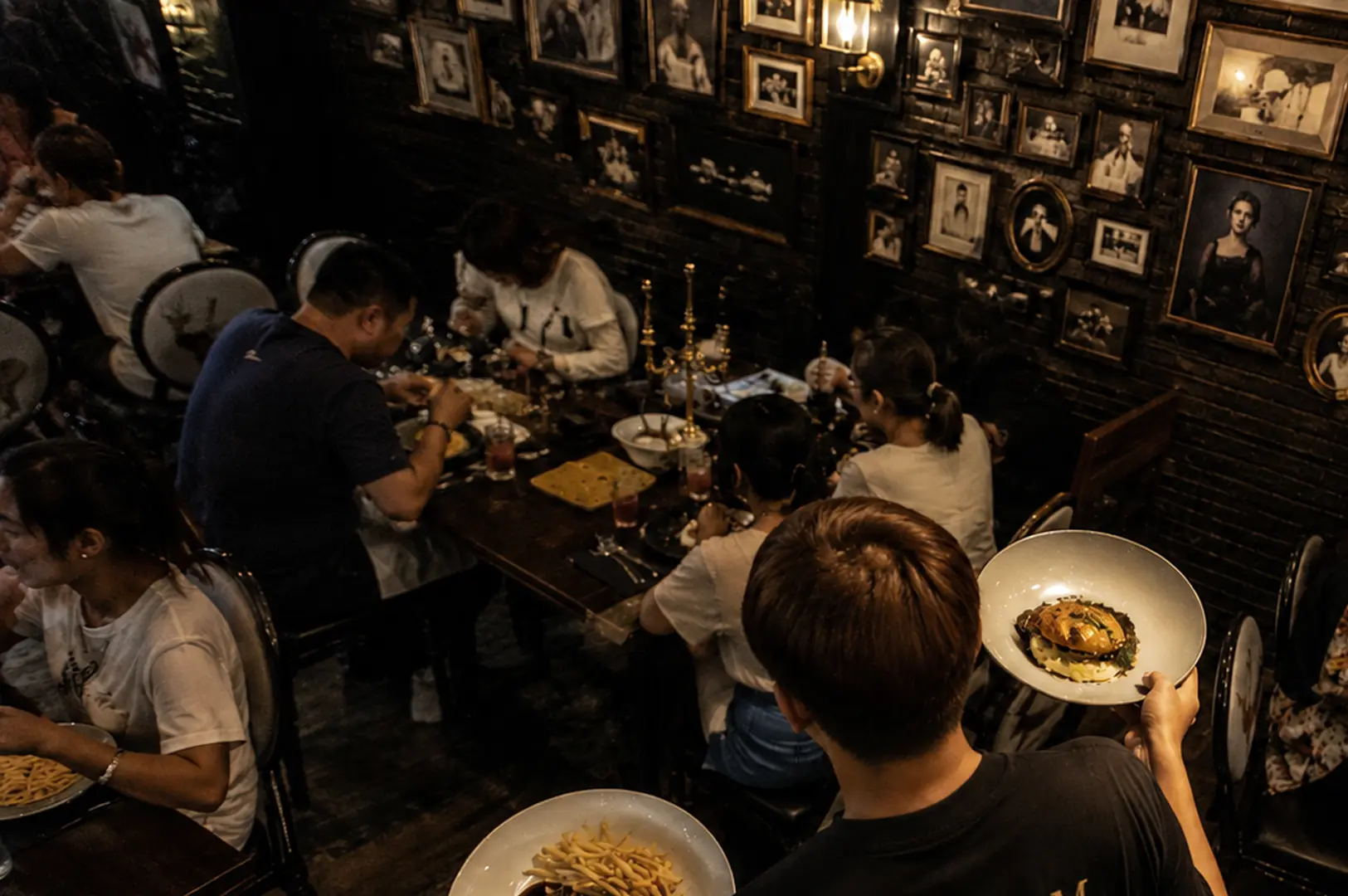 Guests dining inside Platform 1094 surrounded by wizard-themed wall portraits.