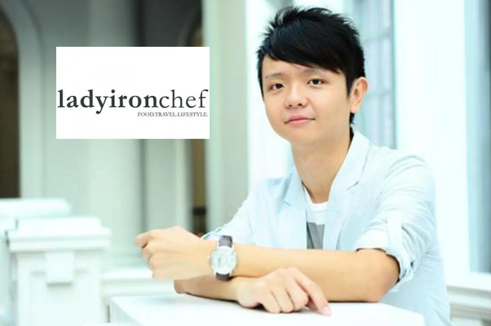 A young person with spiky dark hair wearing a light blue blazer and silver watch, posing thoughtfully beside the Ladyironchef food and travel blog logo