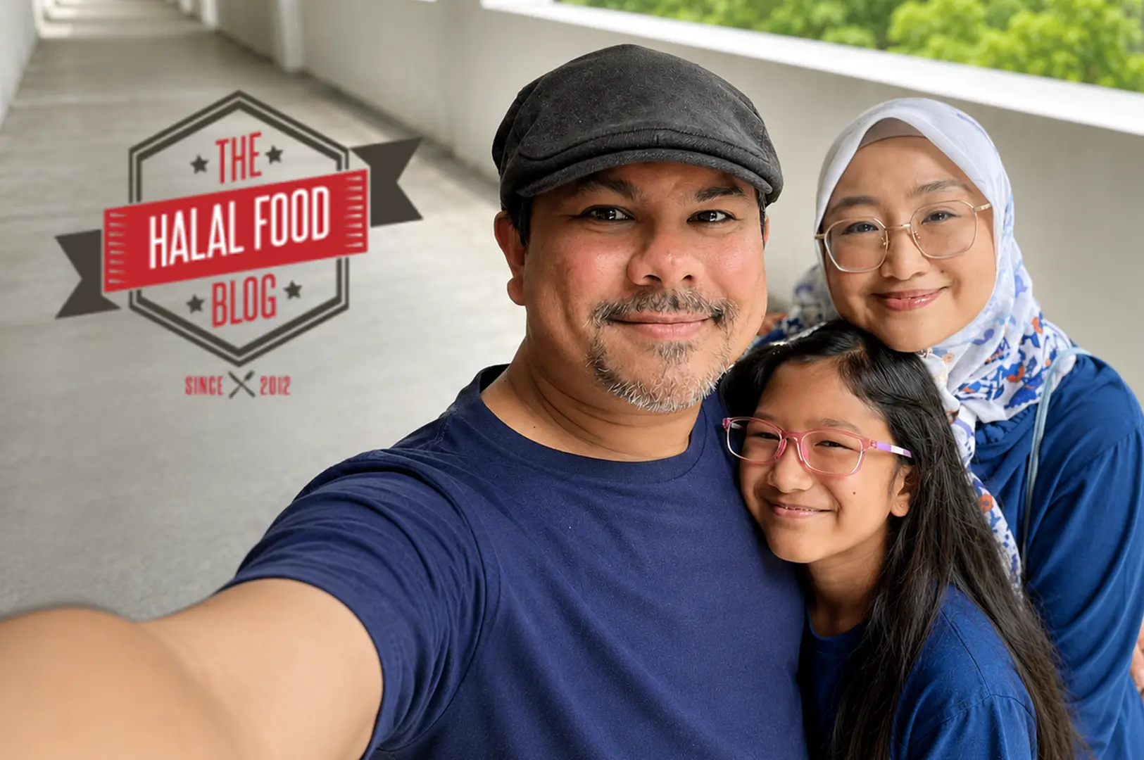 A family of three—a father in a navy shirt and cap, mother wearing a white hijab, and daughter with pink glasses—taking a happy selfie with The Halal Food Blog logo overlay