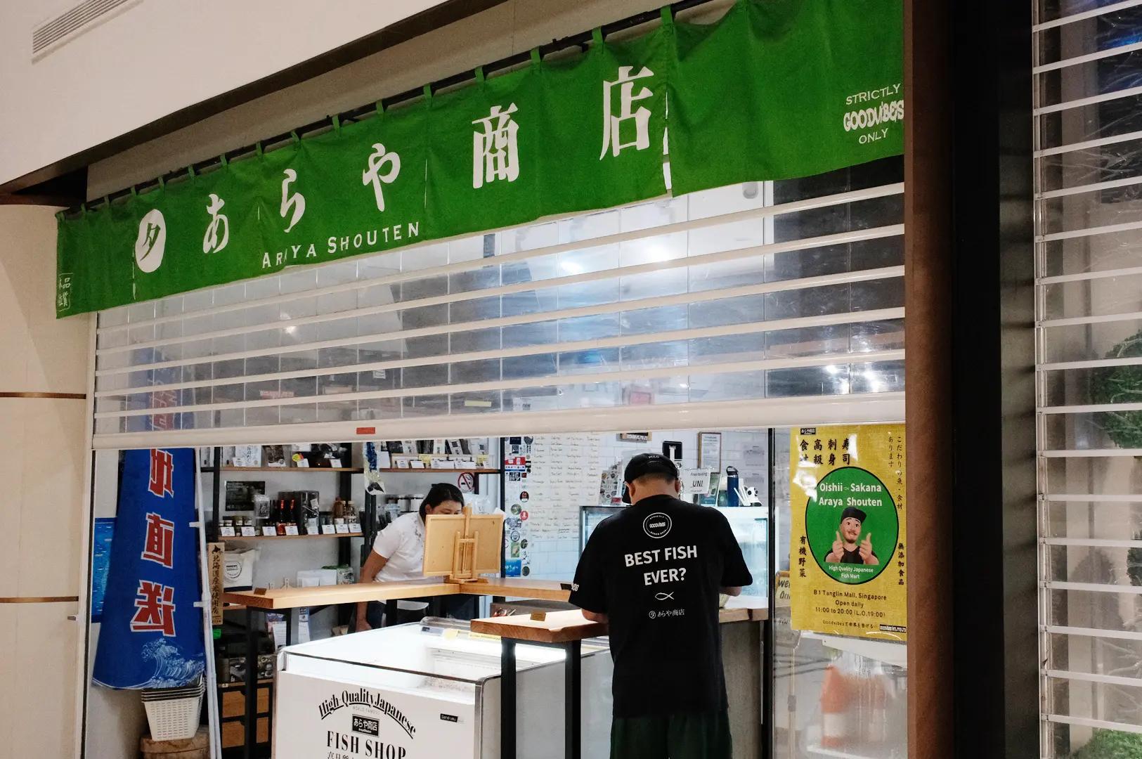 Araya Shouten Japanese seafood shop with a green noren curtain and staff serving customers.