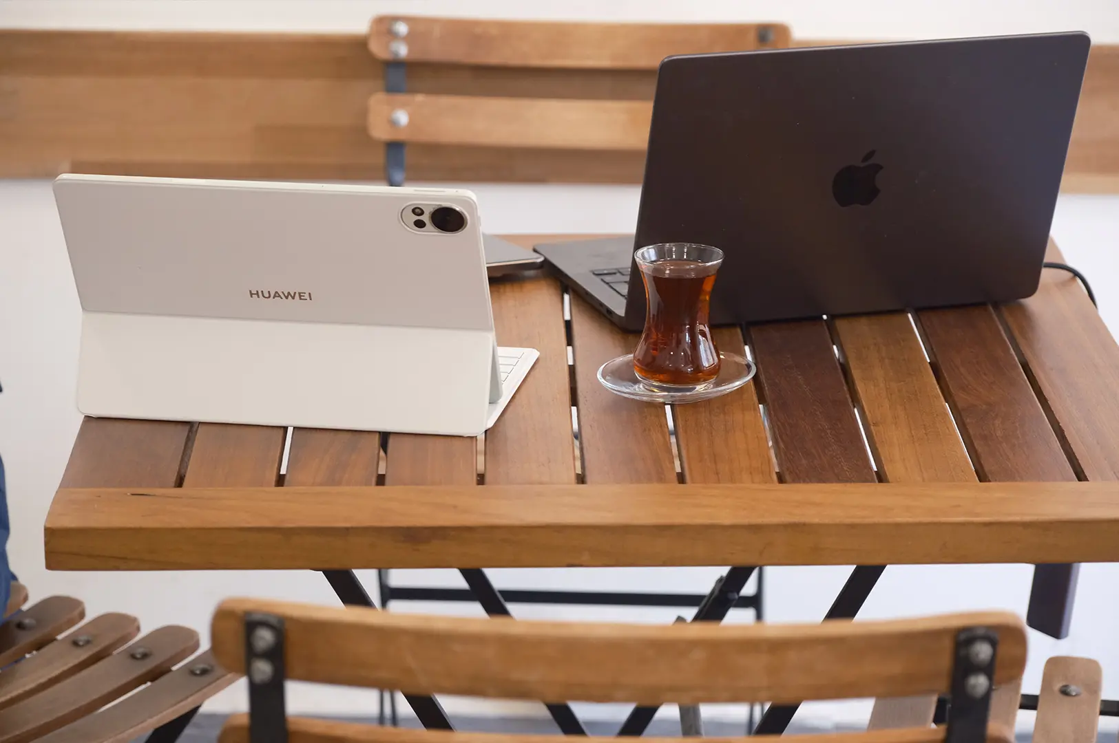 Laptops and a cup of coffee on a cafe table set up for remote work.