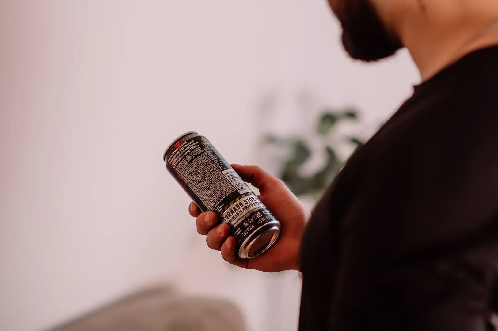 Person reading the nutrition label on a canned prebiotic soda.