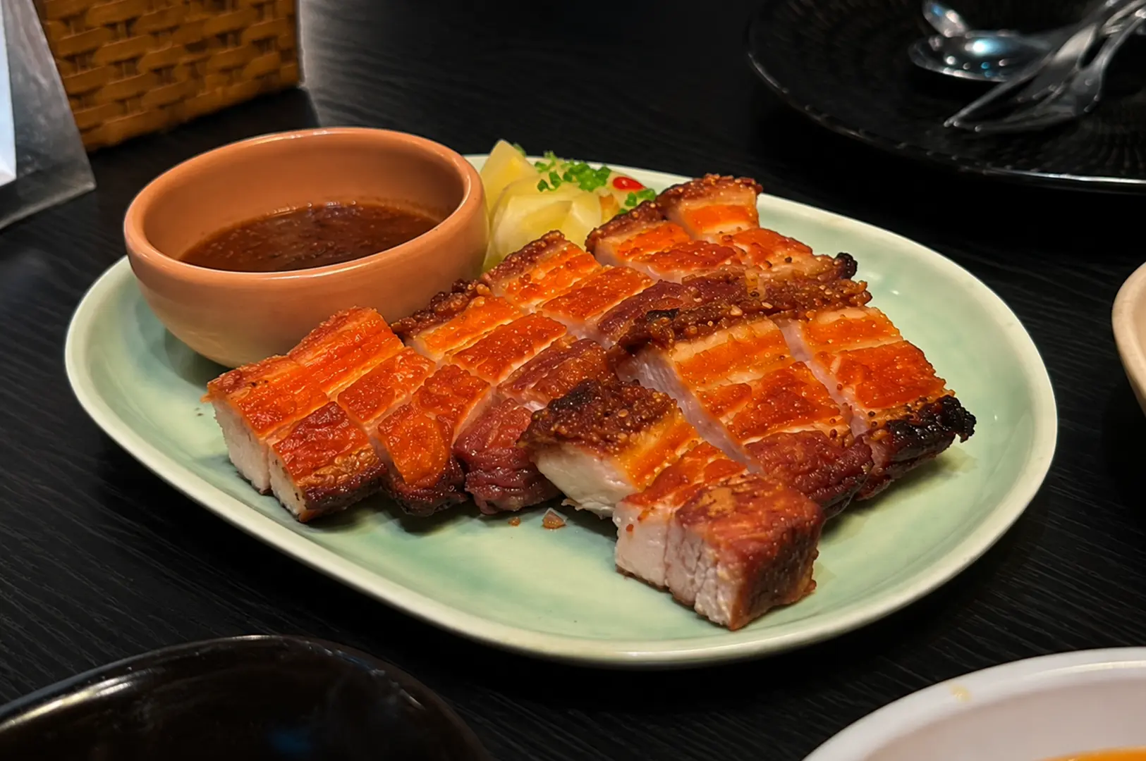Triple Cooked Crackling Pork Belly served with dipping sauce and pickled vegetables.