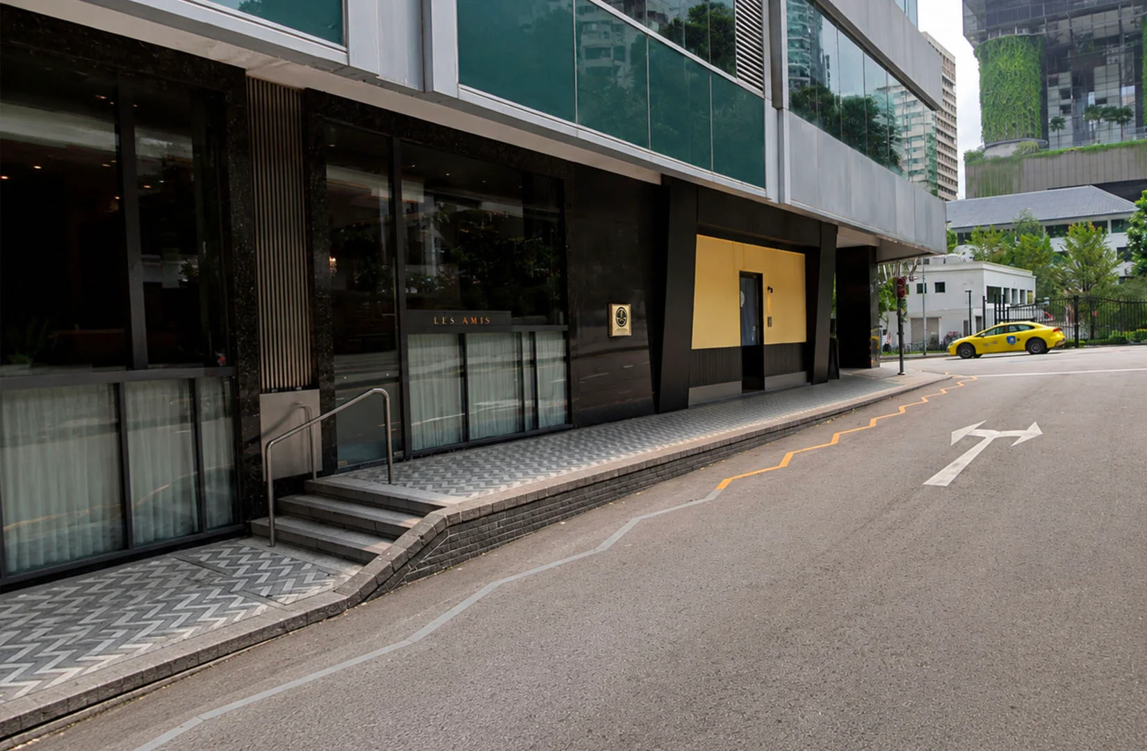 Daytime exterior of Les Amis restaurant located along a quiet city street.