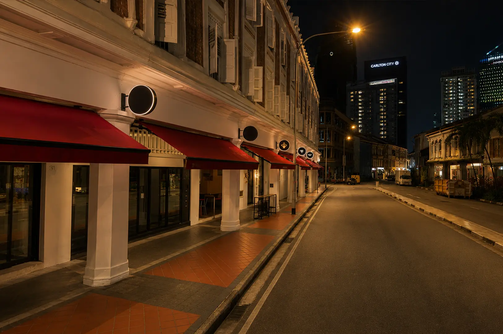 Night view of The Elephant Room exterior with heritage shophouses and red awnings.