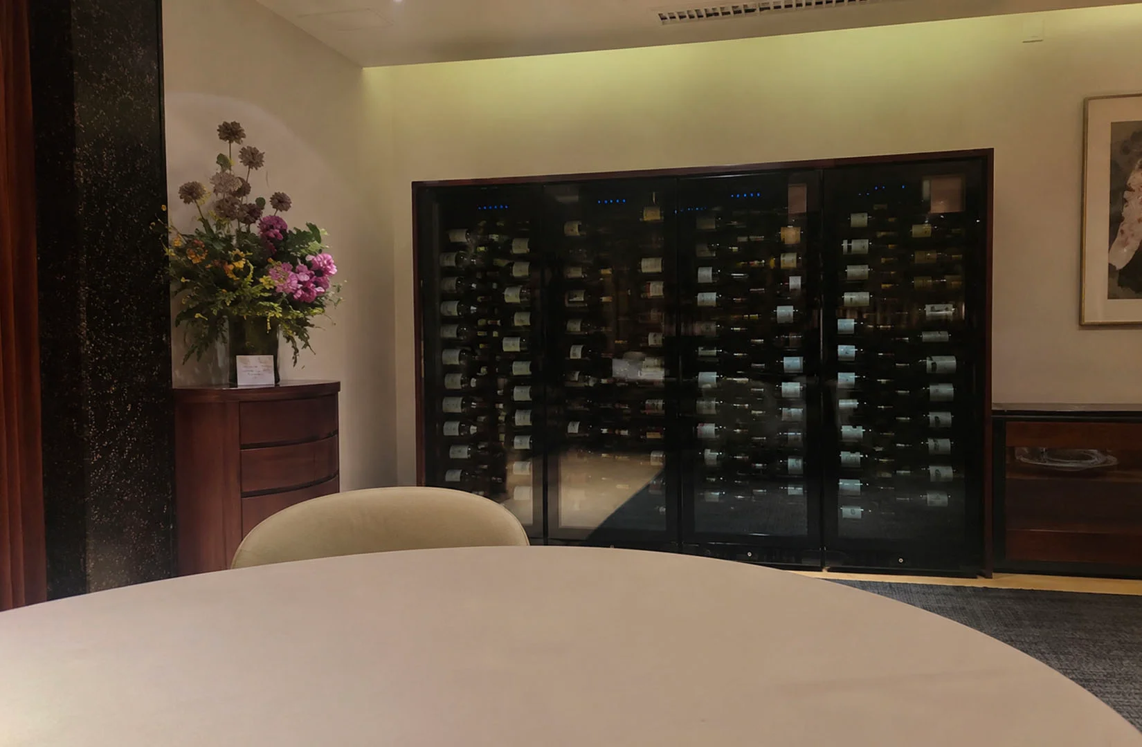 Private dining area at Les Amis featuring a large wine cellar display and elegant décor.