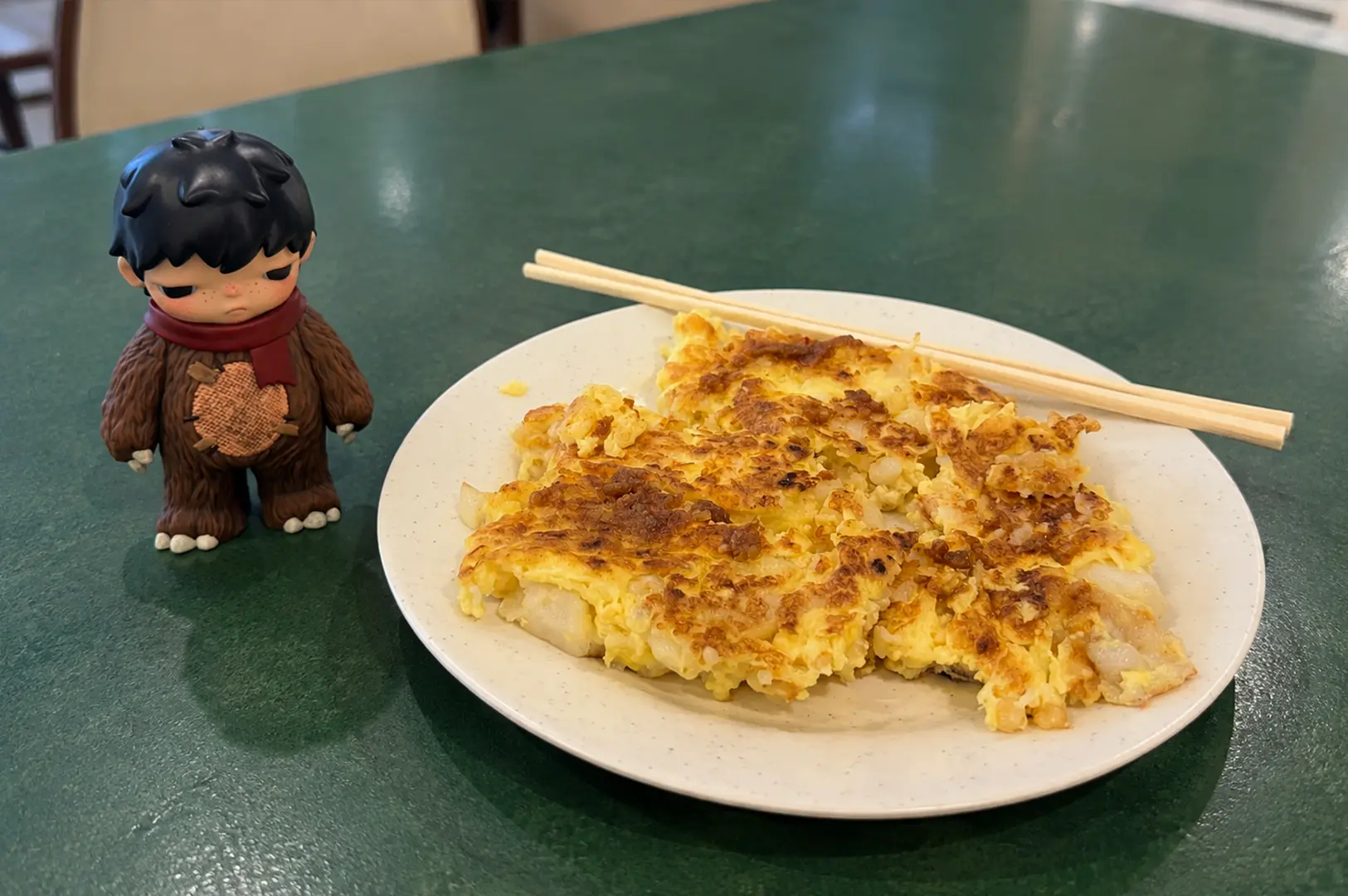 A plate of crispy Singapore carrot cake, made with fried radish cake and egg, served at a hawker centre.
