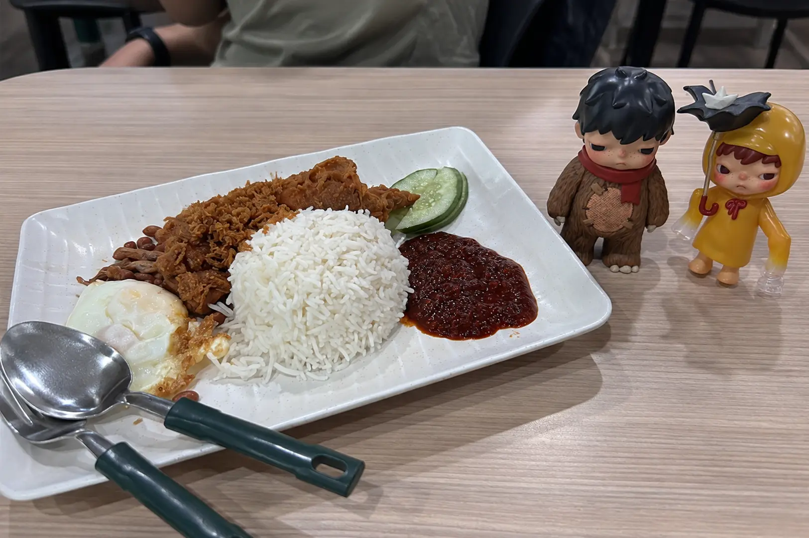 Singapore nasi lemak with coconut rice, fried chicken, egg, peanuts, cucumber and a generous serving of sambal.