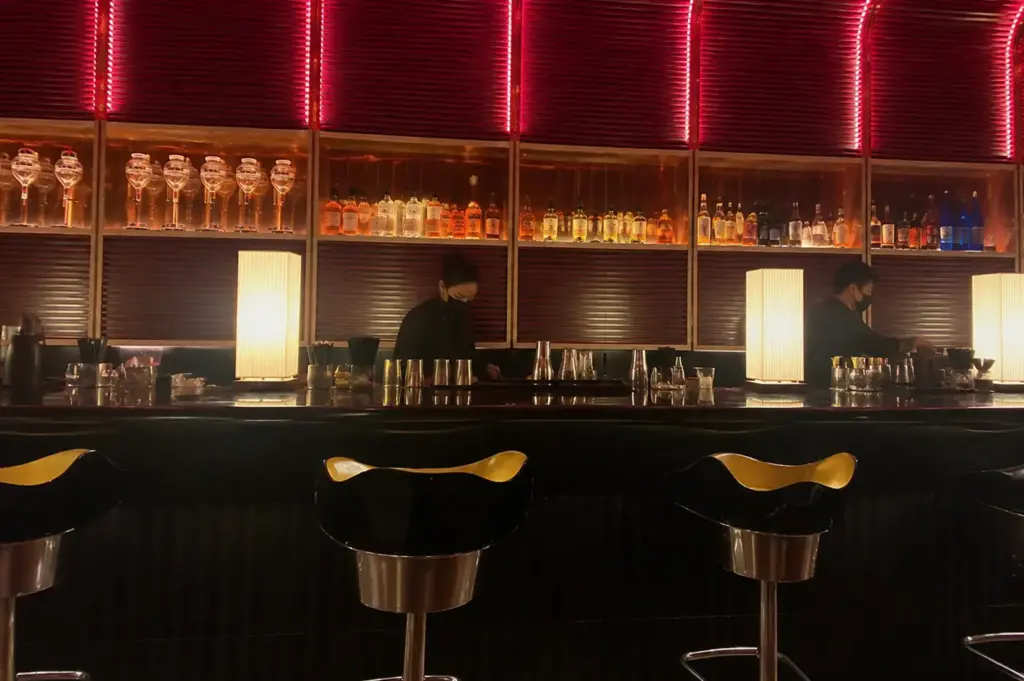 Sen-ryo bar interior with illuminated shelves and counter seating