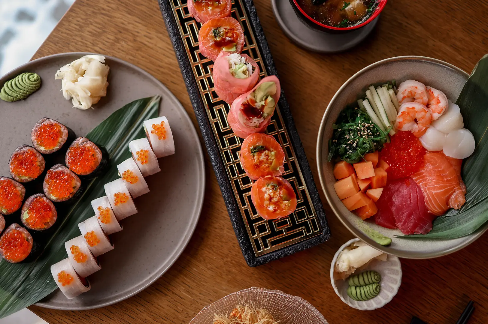 Japanese sushi spread featuring rolls, sashimi rice bowl, and specialty appetizers.