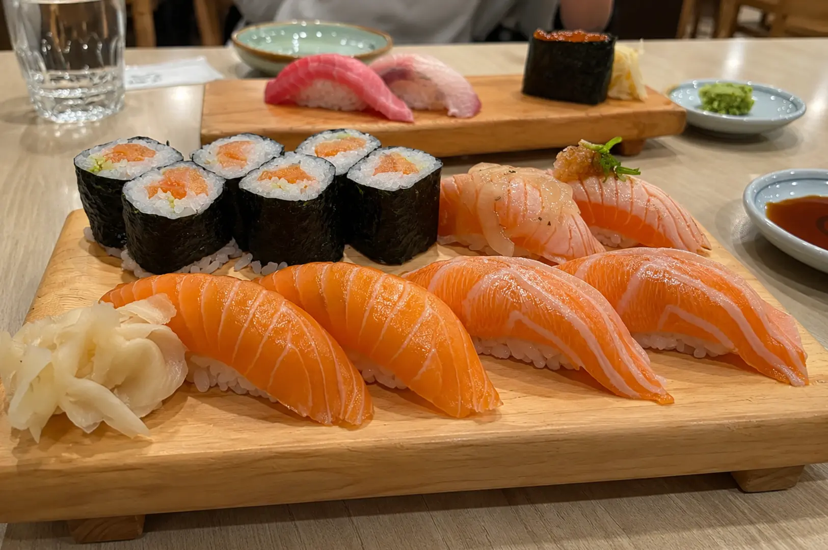 Salmon nigiri, sushi rolls, and premium nigiri assortment served on wooden platters.
