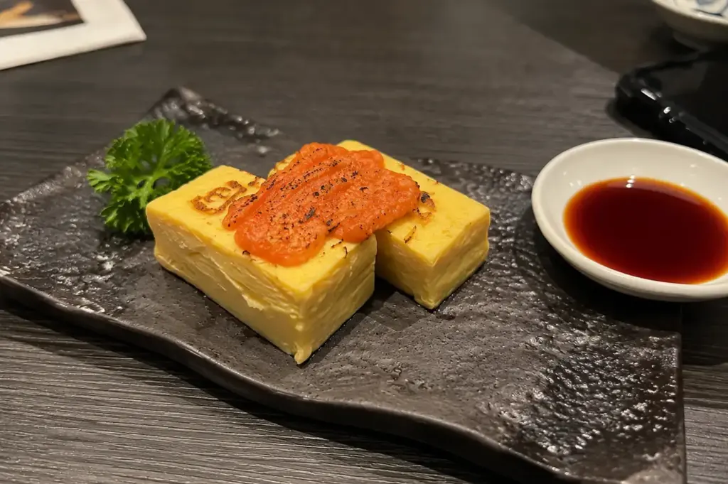 Japanese tamagoyaki topped with seared mentaiko and soy sauce