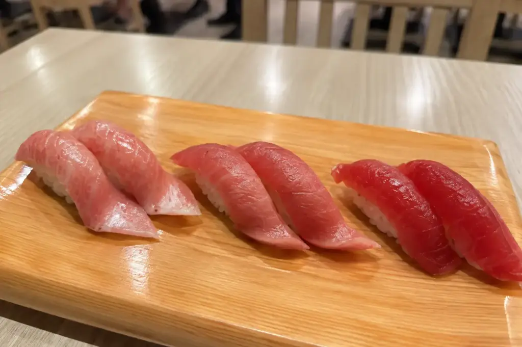 Maguro sushi selection featuring Akami, Chutoro, and Otoro tuna served on a wooden sushi board.