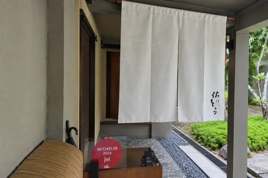 Japanese restaurant entrance with white noren curtains and Michelin 2024 sign