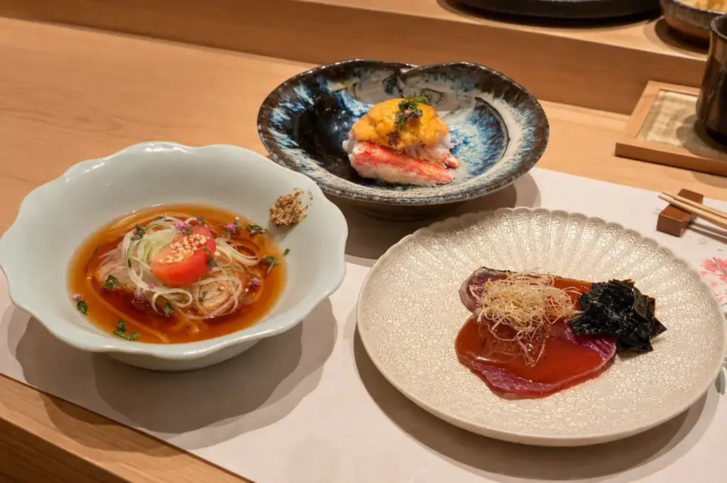 Three beautifully plated Japanese omakase dishes served at the sushi counter