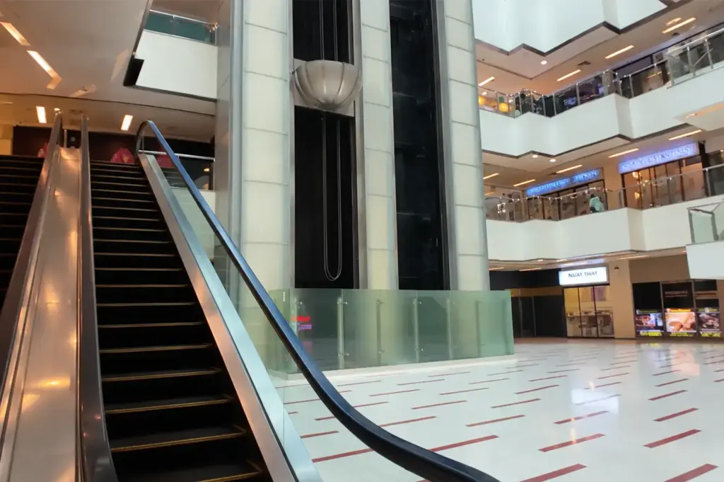 Interior view of Cuppage Plaza showing its bright open atrium, escalator, and multi-level shopping area.